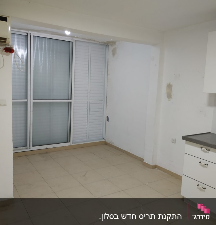 חלון אלומיניום עם תריסים סגורים בחדר ריק